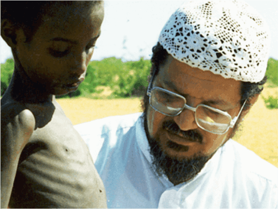Dr. Abdul Rahman Al-Sumait comforting a starving kid in Africa